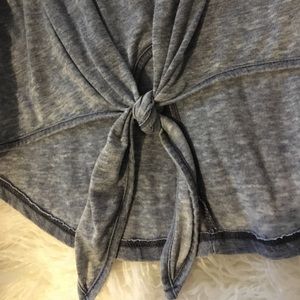 A blue tank top with tie at bottom